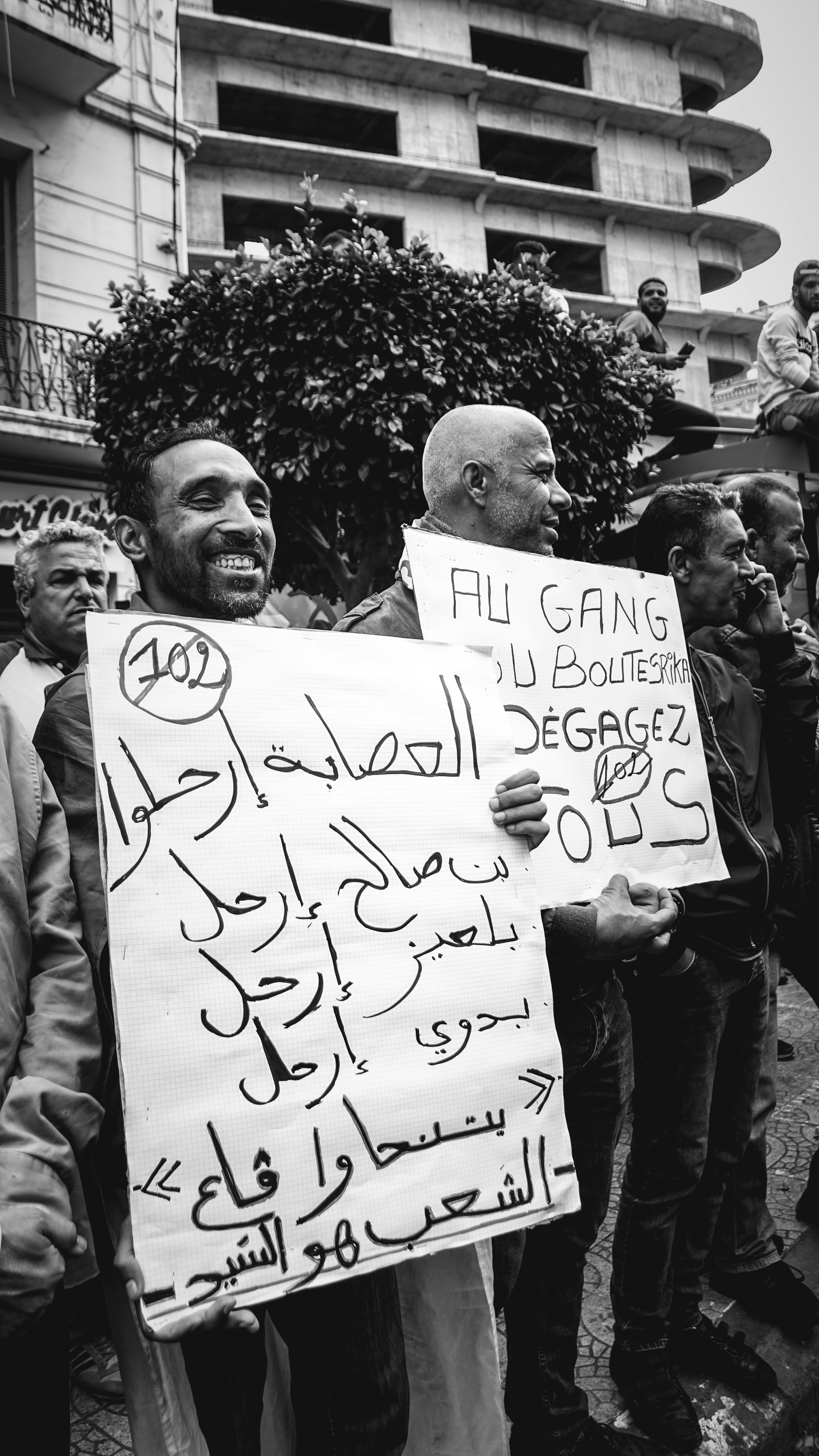 people holding signs in front of building